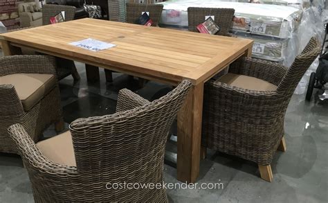 A gorgeous acacia wood table is surrounded by six cozy. . Costco teak dining set